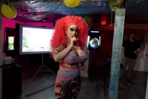 Brigitte Bandit holds a mic at a legiSLAYtion event.